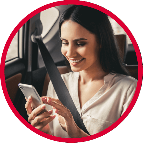 Smiling woman checking deals on her phone in the car